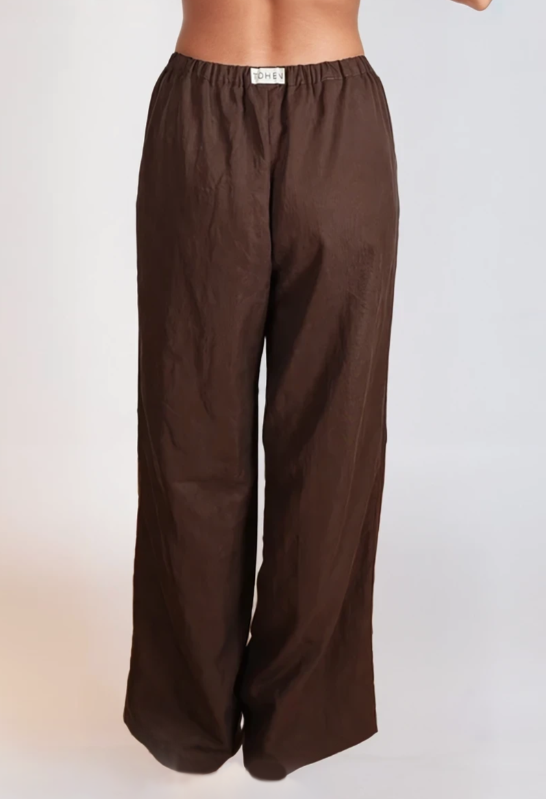 Brown elasticated wide-leg pants with relaxed drape, finished with a small Tohen label on the back waistband