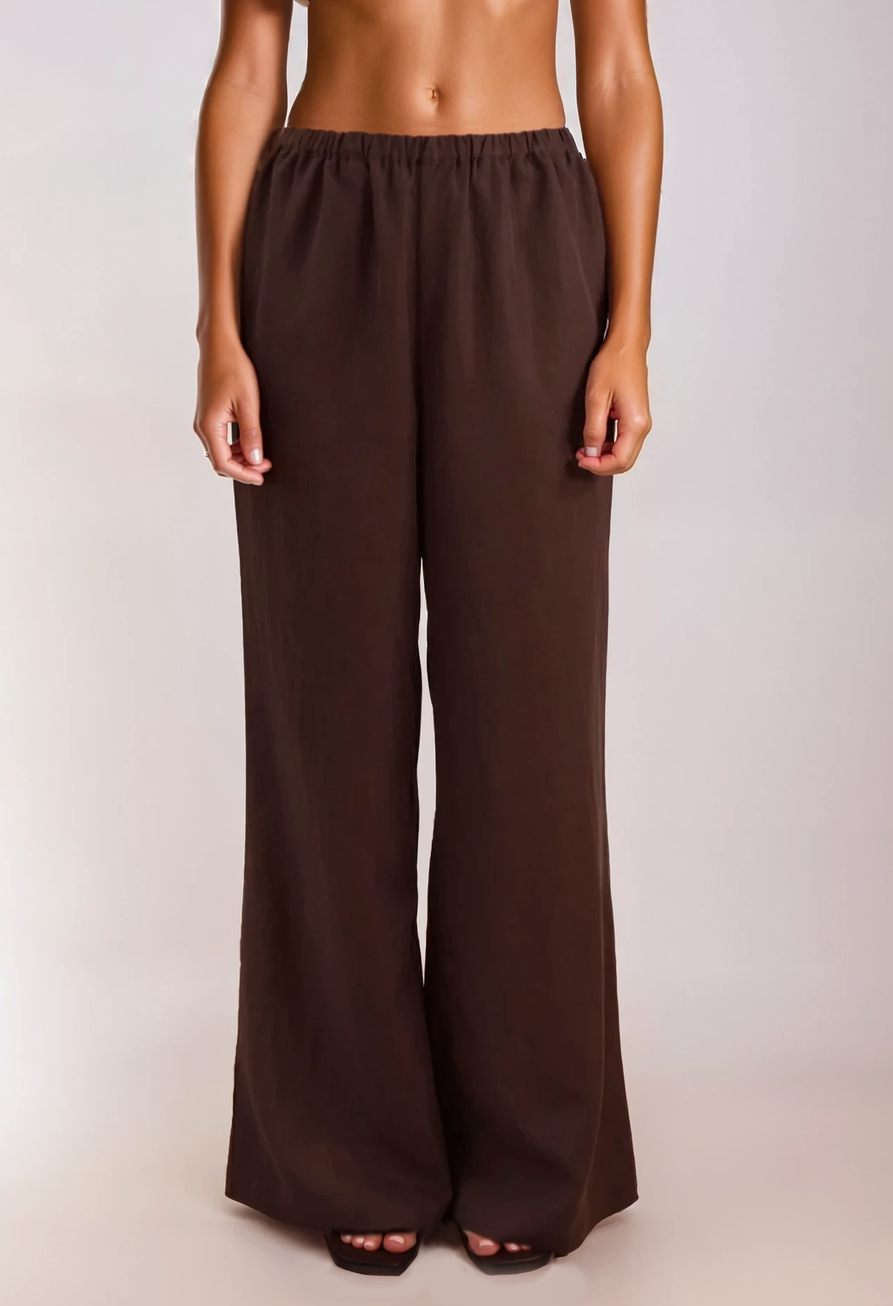 Brown elasticated wide-leg pants with relaxed drape, finished with a small Tohen label on the back waistband